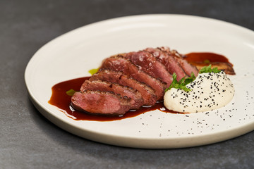Baked turkey Fillet with Celery Puree and sauce on white plate