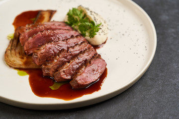 Baked turkey Fillet with Celery Puree and sauce on white plate