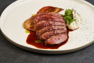 Baked turkey Fillet with Celery Puree and sauce on white plate