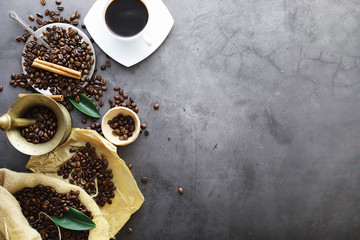 Bag of coffee. Coffee beans roasted on the table. Coffee beans with green leaves for cooking.