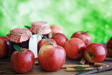 Fresh apples on a wooden board. Harvest of red apples. Fruits and cinnamon on the table.