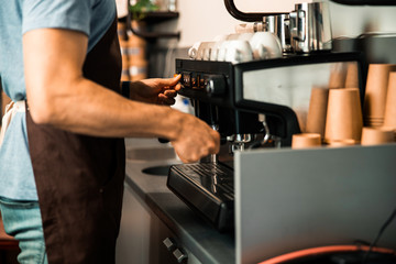 Cropped photo of man preparing coffee drink in cafe