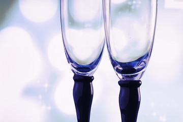 Background with tall glasses for sparkling wines. Champagne and spray in glass glasses. Celebratory drink with reflection.