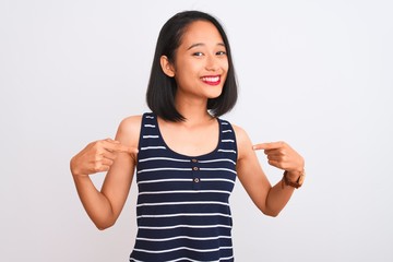 Young chinese woman wearing striped t-shirt standing over isolated white background looking...