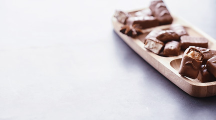 Chocolate bars on a black background in backlight. Chocolate with filling. Sweet sweets for snack and tea.