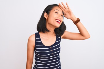 Obraz na płótnie Canvas Young chinese woman wearing striped t-shirt standing over isolated white background very happy and smiling looking far away with hand over head. Searching concept.