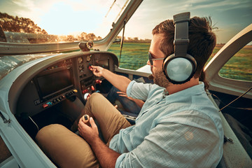 Stylish man pilot in a small plane prepare take off