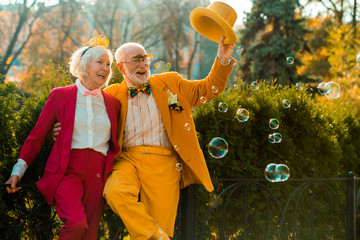 Happy elderly couple looking at bubbles outdoors