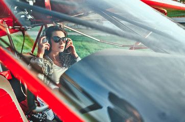 Woman pilot sitting in cabin of small aircraft