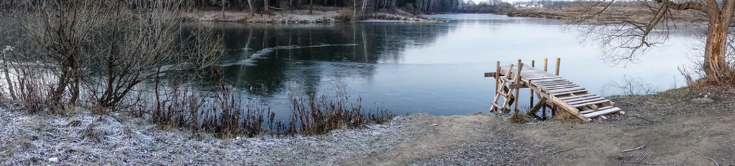 Winter landscape. The frozen lake is covered with new clean ice. panorama