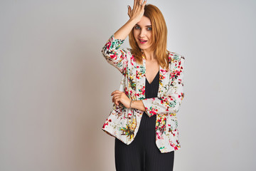 Young caucasian business woman wearing spring floral jacket suit over isolated background surprised with hand on head for mistake, remember error. Forgot, bad memory concept.