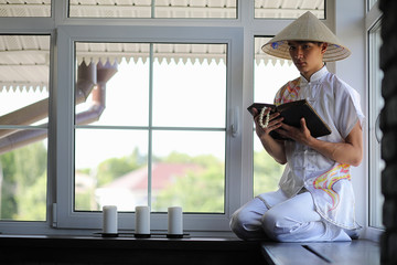 Asian boy in kimono reading an old book