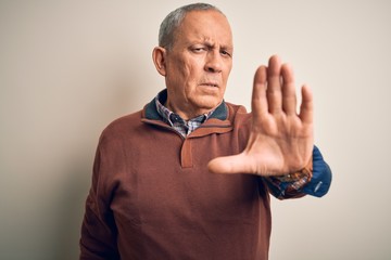 Senior handsome man  wearing elegant sweater standing over isolated white background doing stop...