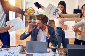 Group of business workers working together. Partners stressing one of them at the office