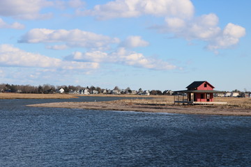 Fototapeta na wymiar Old weathered red fishing shack on coastal New England pier beach 