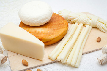 Smoked cheese, decorated with walnuts, isolated on a white background. The concept of cheese.