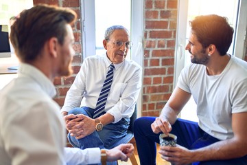 Handsome businessmen smiling happy. Sitting with smile on face speaking taking rest at the office