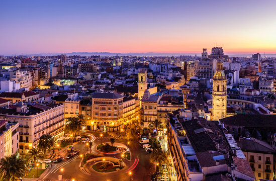 Sightseeing of Spain. Aerial view of Valencia at sunset. Illuminated Plaza de la Reina, cityscape of Valencia.