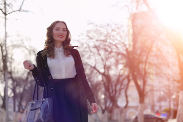 Girl business woman in the spring on a walk in a coat