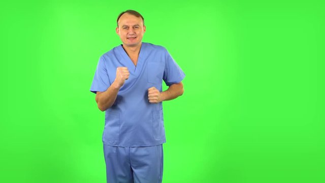Medical man is dancing funny, rejoices. Green screen