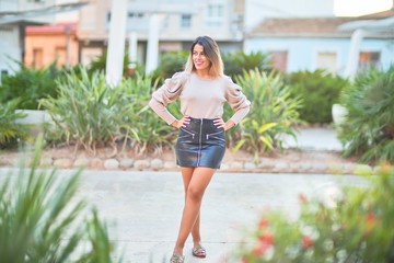 Young beautiful woman wearing sweater and skirt standing at the town street