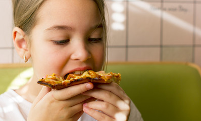 Cute little girl eating pizza