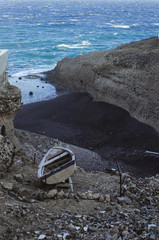 Abandon paddle boat near the cliffs and beach with the sea and waves in the background, with copy space.