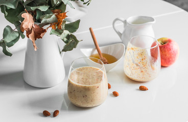 Honey, almonds, dates, apples, almond milk protein smoothies on a light table. Healthy diet protein drink