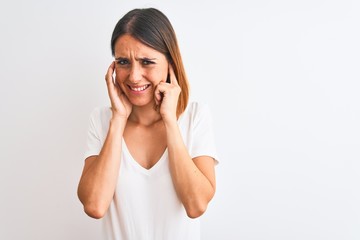 Fototapeta premium Beautiful redhead woman wearing casual white t-shirt over isolated background covering ears with fingers with annoyed expression for the noise of loud music. Deaf concept.