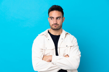 Young handsome man over isolated blue background thinking an idea