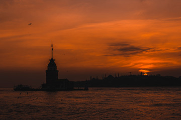 Silhouette of Maiden Tower and Istanbul during sunset golden hour
