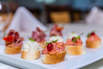 Detail of a canapes of a meal at an event, wedding, meeting or congress with food. Canapes decorated on the dish