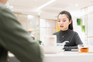 Young asian woman talking face to face in restaurant