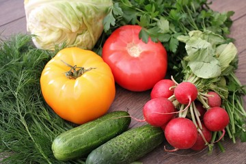 Tomatoes cucumbers cabbage radish dill and parsley on a table in the village