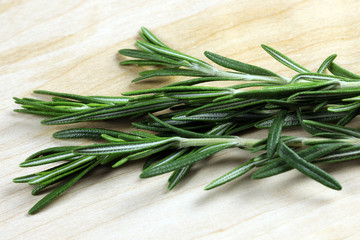 bunch of fresh rosemary on wooden background