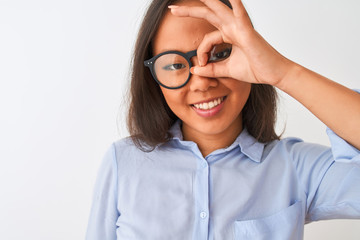 Obraz premium Young chinese woman wearing shirt and glasses standing over isolated white background with happy face smiling doing ok sign with hand on eye looking through fingers