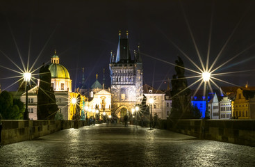 The Charles Bridge in Prague in the evening, in the light of lanterns. Medieval bridge over the Vltava River, which connects historic districts Lesser and Stare Mesto.