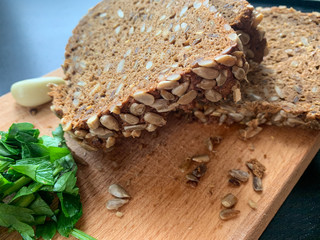 Organic brown bread with sunflower seeds, parsley and a piece of garlic