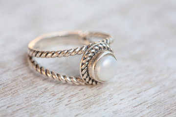 Silver ring on neutral bright wooden background