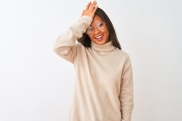Young chinese woman wearing turtleneck sweater and glasses over isolated white background surprised...
