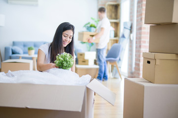 Young beautiful couple open cardboard boxes to order new home