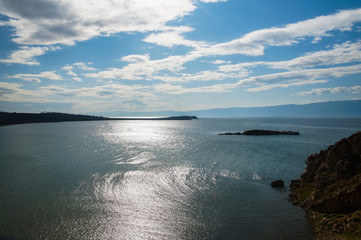 blue water going into the horizon of the lake and the rocks