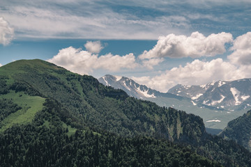 View of the mountain meadow and mountain. Beautiful clouds and mountain in a blue haze.