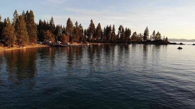 Lake Tahoe slow motion water waves and bay with boat dock at sunset