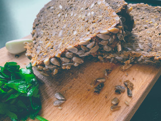 Organic brown bread with sunflower seeds, parsley and a piece of garlic
