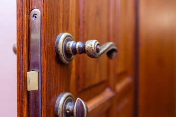 Vintage door handle and door lock on luxury mahogany door