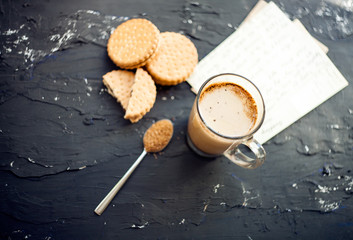 Cup of Coffee with a Cookies and brown shugar. Symbolic image. Coffee background. Sweet dessert. Wooden background. Close up. Freshly brewed cup of cafe latte coffee served with chocolate cookies
