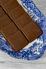 Chocolate mint wafers on a patterned blue and white plate.  Grey wood background