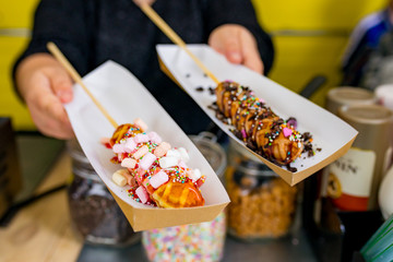 Waffle on a stick with toppings ready to be served