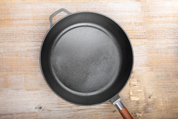 New cast-iron grill pan on a wooden background.